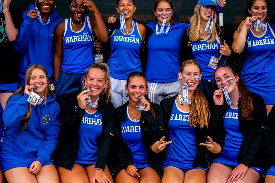 The Vikings Tennis Team take a bite of the State Finalist Medals.