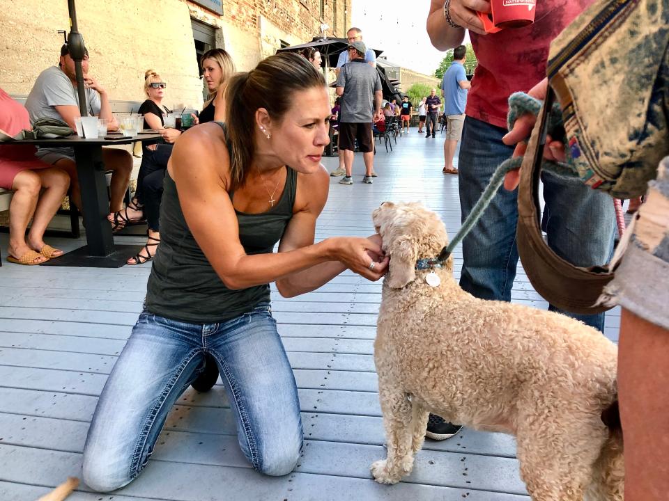 Valerie Smith of Pecatonica pets a dog she met on Thursday, July 14, 2022, during Dinner On the Dock at the Prairie Street Brewing Company. Prairie Street is one of more than 20 places in the Rockford area that allow customers to bring their dogs with them while drinking or dining on their patios and decks.