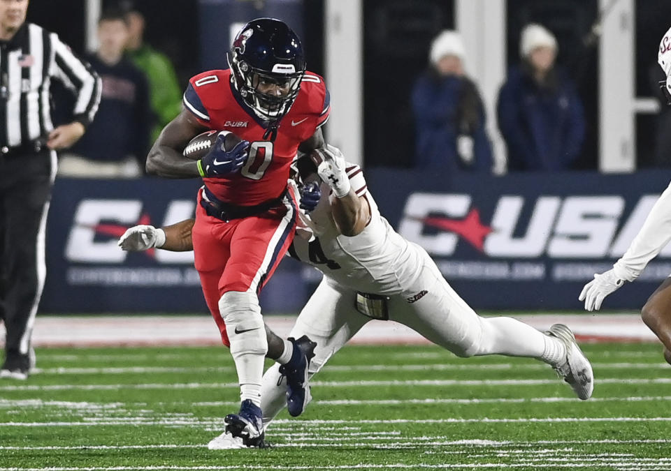 Liberty running back Billy Lucas tries to get away from New Mexico State linebacker Sone Aupiu during the Conference USA championship NCAA college football game Friday, Dec. 1, 2023, in Lynchburg, Va. (Paige Dingler/The News & Advance via AP)