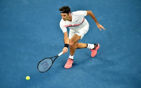 Switzerland's Roger Federer plays a forehand return to Czech Republic's Tomas Berdych during their men's singles quarter-finals match on day 10 of the Australian Open tennis tournament in Melbourne on January 24, 2018 - Credit: AFP
