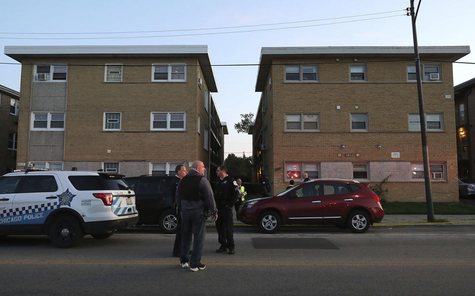 Police officers guard the scene outside the apartment building. Source: AP