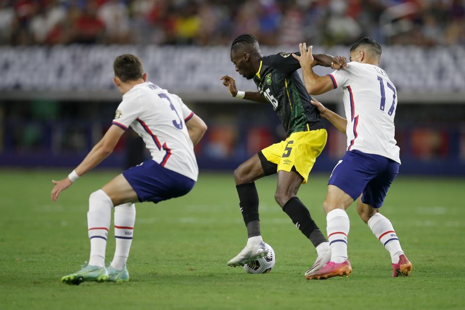 United States defender Sam Vines (3) and midfielder Sebastian Lletget (17) pressure Jamaica forward Blair Turgott (15) as he handles the ball in the first half of a 2021 CONCACAF Gold Cup quarterfinals soccer match, Sunday, July 25, 2021, in Arlington, Texas. (AP Photo/Brandon Wade)