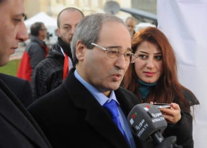 FILE PHOTO: Syria's Deputy Foreign Minister Faisal Mekdad, a member of the Syrian government delegation, speaks to a journalist upon his arrival for the first meeting face-to-face with Syrian opposition delegation and the U.N.-Arab League envoy for Syria Lakhdar Brahimi (not pictured) at a U.N. office in Geneva January 25, 2014. REUTERS/ Stringer