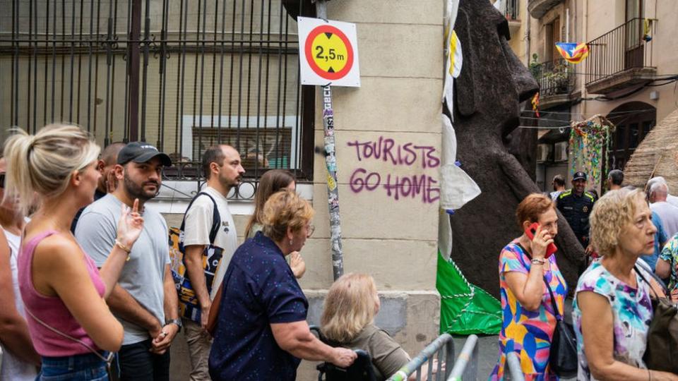 A graffiti against tourism appears in one of the streets that residents decorate during the Gracia Festival, the most popular in the city, in Barcelona, Spain, on August 16, 2023