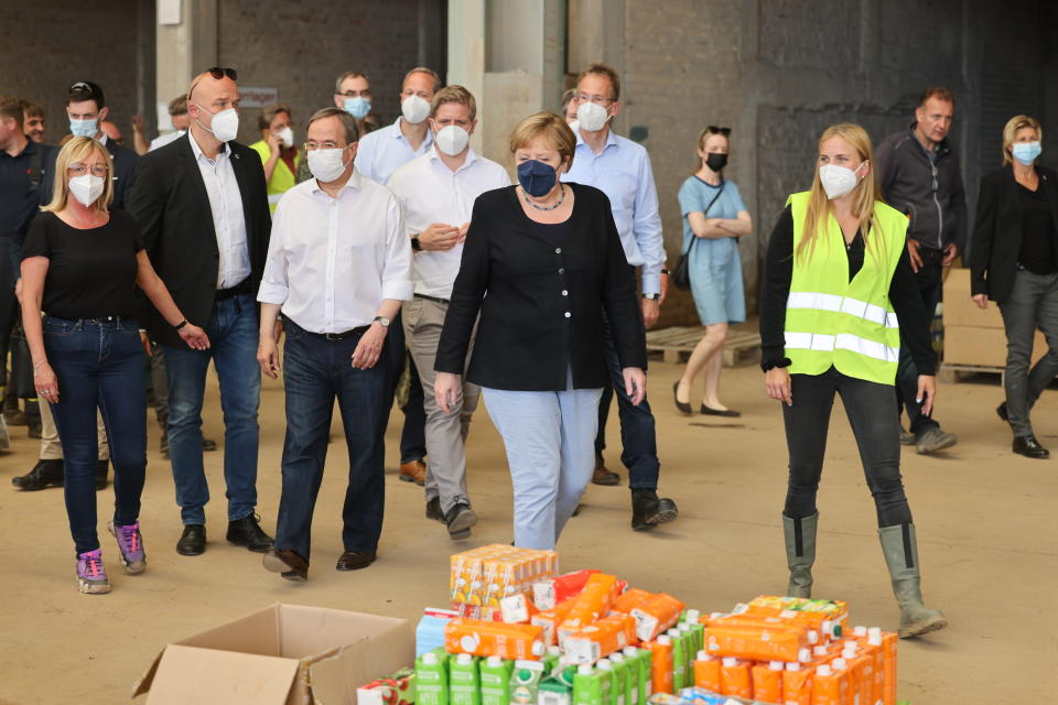 Bundeskanzlerin Angela Merkel und NRW-Ministerpräsident Armin Laschet besichtigen ein Lager mit Lebensmitteln bei ihrem Besuch im vom Hochwasser betroffenen Gebiet von Bad Münstereifel (Bild: Oliver Berg/dpa-Pool)