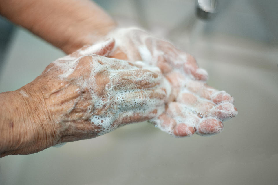 Coronavirus Covid-19 old woman is washing her hands with soap, prevention, quarantine