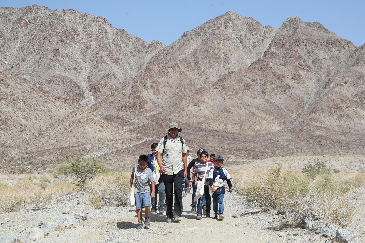 Oscar Ortiz leads a group of students from Las Palmitas Elementary School on a hike in the La Quinta Cove Oasis.  Ortiz is with Friends of the Desert Mountains and was teaching the students about their local environment in La Quinta, Calif., May 10, 2023. 