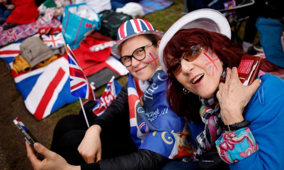 Royal fans wait for the coronation procession to arrive in central London