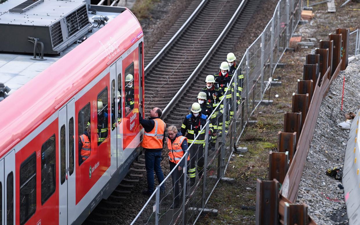 Firefighters go to an S-Bahn together with railway staff at a railway site in Munich, Germany, Wednesday, Dec. 1, 2021. Police in Germany say three people have been injured including seriously in an explosion at a construction site next to a busy railway line in Munich. - Sven Hoppe 