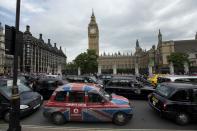 London taxi drivers park their cabs on Parliament Square, outside the houses of Parliament as they take part in a protest in reaction to not being allowed to use the Olympic driving lanes in London, Tuesday, July 17, 2012. (AP Photo/Matt Dunham)