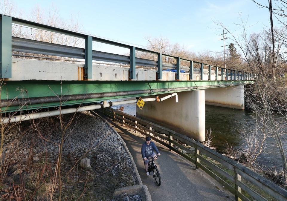 A bicyclist rides the Hike and Bike Trail under the state Route 91 bridge over the Cuyahoga River on March 25 in Munroe Falls.