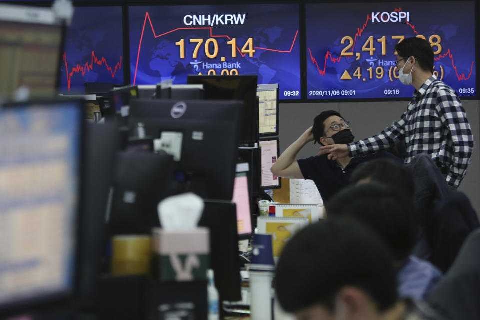 Currency traders work at the foreign exchange dealing room of the KEB Hana Bank headquarters in Seoul, South Korea, Friday, Nov. 6, 2020. Asian stock markets were mixed Friday after Wall Street rose amid protracted vote-counting following this week's U.S. elections. (AP Photo/Ahn Young-joon)