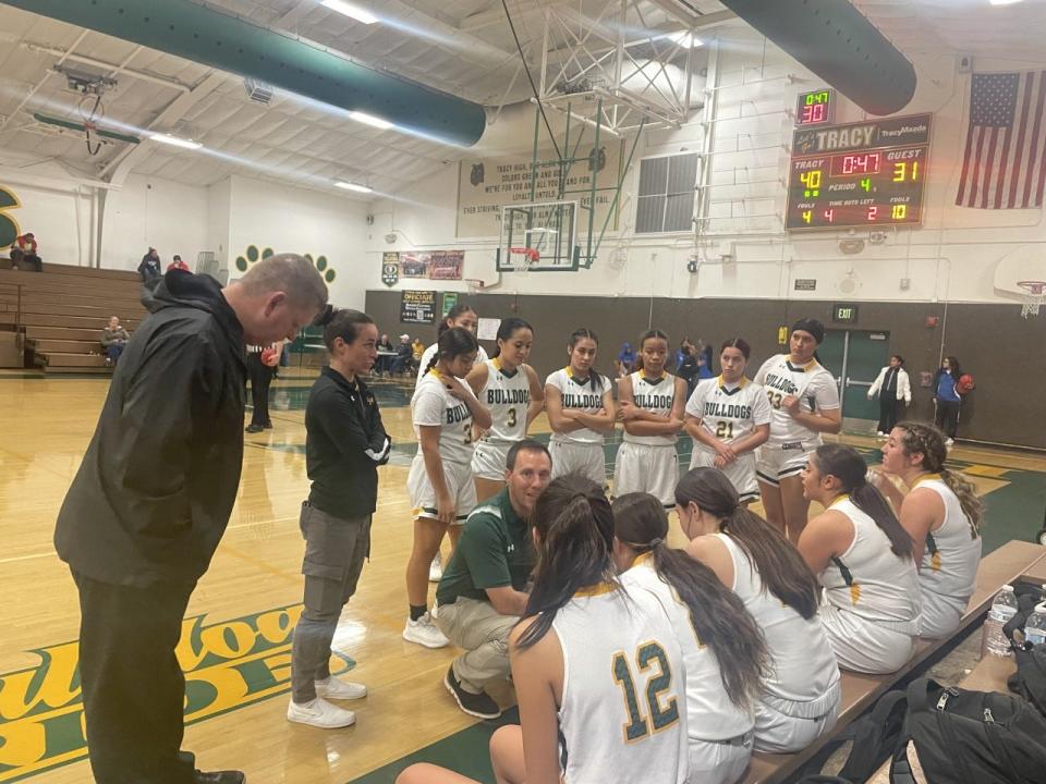 Tracy girls basketball players  hear from their coaches during a fourth quarter timeout in their game against Ripon High School on Thursday, Dec. 29, 2022.