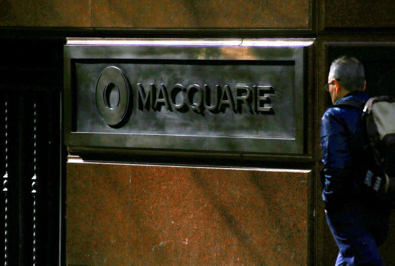 FILE PHOTO: A pedestrian walks past the logo of Australia's biggest investment bank Macquarie Group Ltd which adorns a wall on the outside of their Sydney office headquarters in central Sydney, Australia