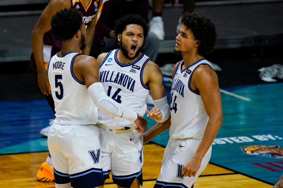 Villanova guard Caleb Daniels (14) celebrates a defensive stop with Justin Moore (5) and Jeremiah Robinson-Earl (24) in the second half of a first round game against Winthrop in the NCAA men's college basketball tournament at Farmers Coliseum in Indianapolis, Friday, March 19, 2021.