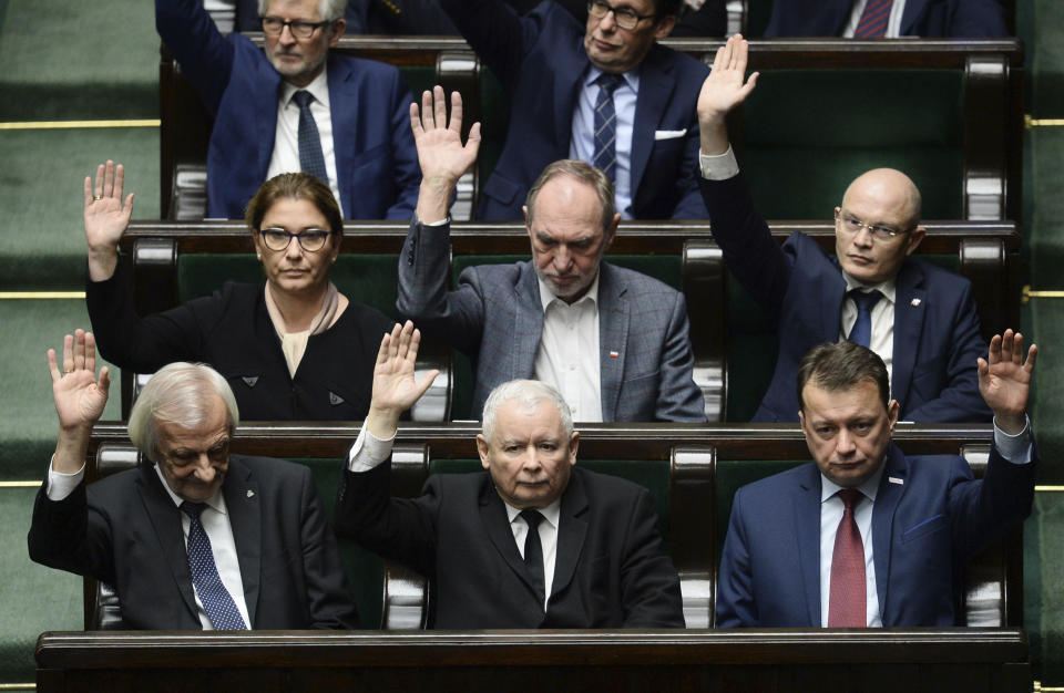 Lawmakers, with ruling party leader Jaroslaw Kaczynski, front row center, vote in favor during the confidence vote in the parliament, in Warsaw, Poland, Wednesday, Dec. 12, 2018. Morawiecki’s conservative government easily survived a confidence vote in parliament that the leader had unexpectedly asked for earlier in the day. Morawiecki, with the ruling Law and Justice party, had said he wanted to reconfirm that his government has a mandate from lawmakers as it pushes through its “great reforms.”(AP Photo/Alik Keplicz)