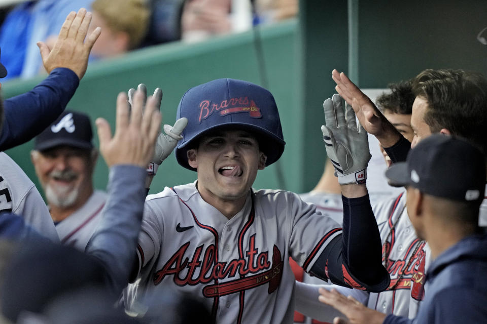 Atlanta Braves' Austin Riley celebrates in the dugout after hitting a solo home run during the first inning of a baseball game against the Kansas City Royals Friday, April 14, 2023, in Kansas City, Mo. (AP Photo/Charlie Riedel)