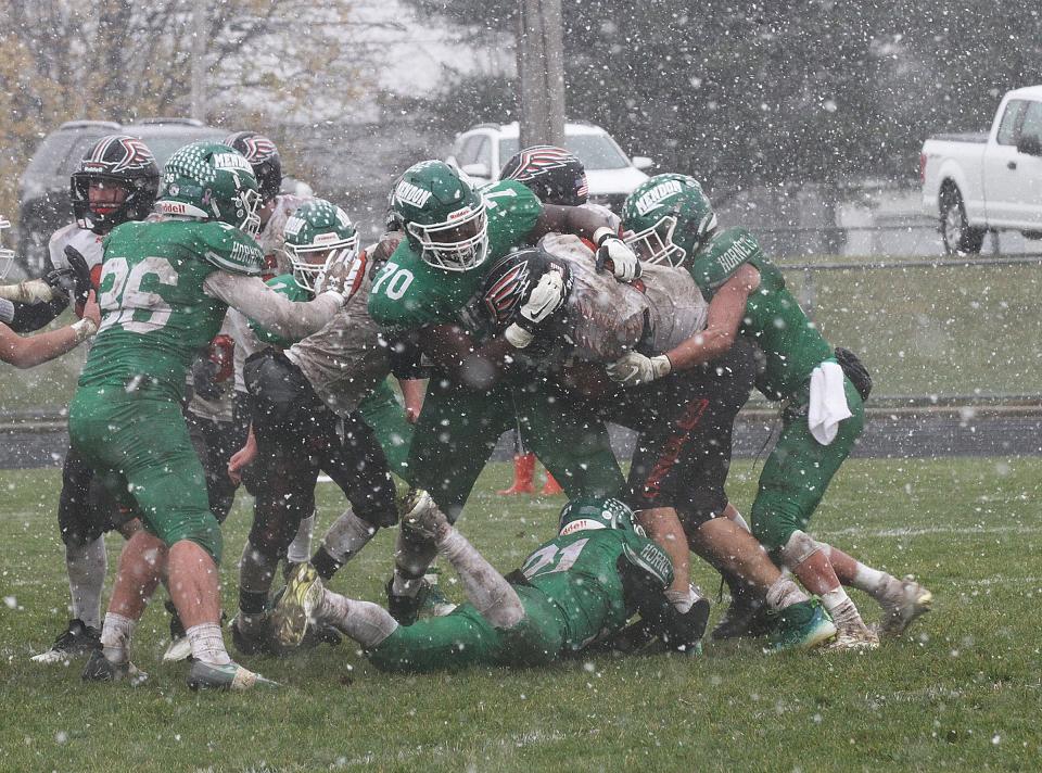 The Mendon defense makes a tackle on Morrice runner Drew McGowan in snowy conditions Saturday afternoon.