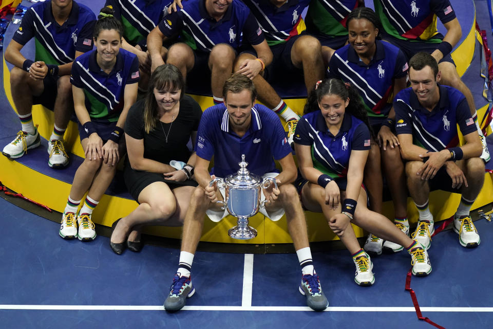 Daniil Medvedev, of Russia, poses for photos with court attendants after defeating Novak Djokovic, of Serbia, in the men's singles final of the US Open tennis championships, Sunday, Sept. 12, 2021, in New York. (AP Photo/Seth Wenig)