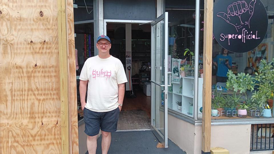 superofficial Owner Jon Matwijec-Walda stands outside his cafe and the plywood barrier put up after the storm blew out the large glass window.
