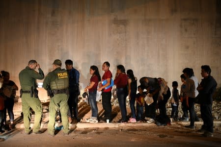 Migrant families turn themselves to U.S. Border Patrol to seek asylum following an illegal crossing of the Rio Grande in Hidalgo