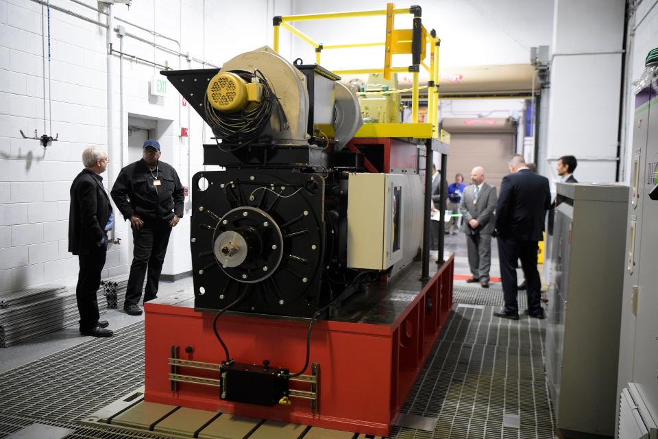 Guests examine the single cylinder, dual-fuel locomotive engine powered by hydrogen at Oak Ridge National Laboratory's National Transportation Research Center, 2360 Cherahala Blvd., in Hardin Valley, Tenn., on Wednesday, Nov. 9, 2022. The engine, being developed by ORNL, Argonne National Laboratory and Wabtec Corporation, is designed to help decarbonize the rail industry throughout North America.