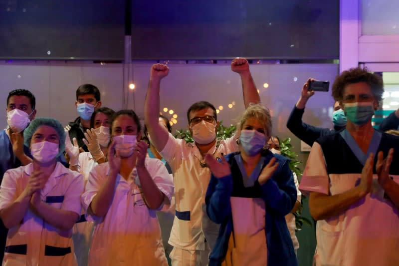 Medical staff from the Fundacion Jimenez Diaz hospital applaud as neighbours applaud from their balconies in support for healthcare workers, during the coronavirus disease (COVID-19) outbreak, in Madrid