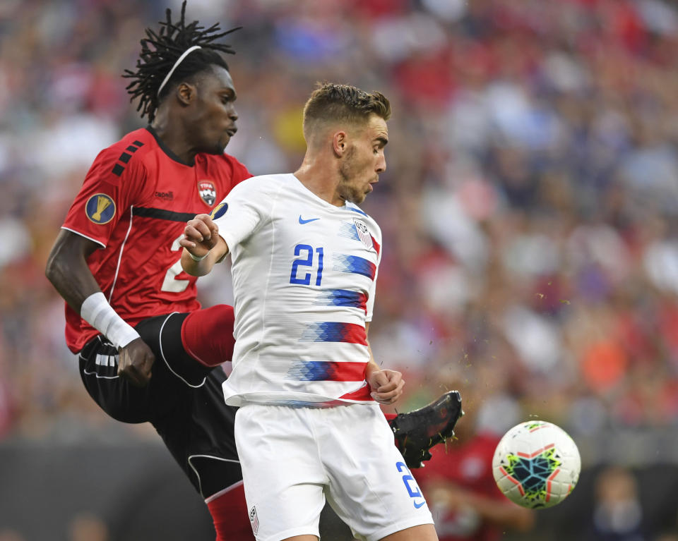 U.S. forward Tyler Boyd plays the ball against Trinidad and Tobago defender Aubrey David during the first half of a CONCACAF Gold Cup soccer match Saturday, June 22, 2019, in Cleveland. (AP Photo/David Dermer)