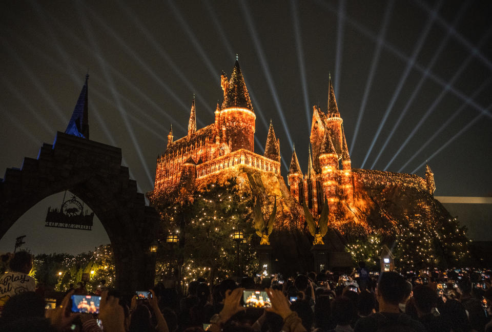 BEIJING, CHINA - SEPTEMBER 23: People watch a light show over Hogwarts Castle in the Wizarding World of Harry Potter attraction at Universal Studios Beijing on September 23, 2021 in Beijing, China. Universal Studios Beijing Resort which features attractions from some of the company's famous film brands including Harry Potter, Transformers, Minions Kung Fu Panda and others as well as restaurants, hotels and a city-walk, officially opened to sell-out crowds on September 20th. It is Universal Studios' fifth global theme park, and is a joint venture between state-owned Beijing Shouhuan Cultural Tourism Investment Co. and Universal Parks & Resorts, a business unit of Comcast NBCUniversal. The park opens at a time of strained U.S. and China relations. (Photo by Kevin Frayer/Getty Images)