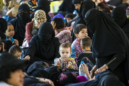 Suspected Uighurs from China's troubled far-western region of Xinjiang, rest inside a temporary shelter after they were detained at the immigration regional headquarters near the Thailand-Malaysia border in Hatyai, Songkhla in this March 14, 2014 file photo. REUTERS/Athit Perawongmetha