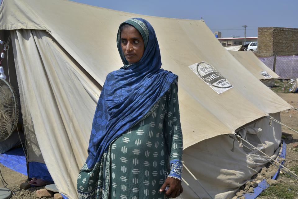 Shakeela Bibi who is pregnant stands beside her tent at a relief camp for flood victims, in Fazilpur near Multan, Pakistan, Sept. 23, 2022. Pregnant women are struggling to get care after Pakistan’s unprecedented flooding, which inundated a third of the country at its height and drove millions from their homes. The UN says around 130,000 pregnant women in flood-hit areas require urgent healthcare and more than 2,000 are giving birth every day, most in unsafe conditions. (AP Photo/Shazia Bhatti)