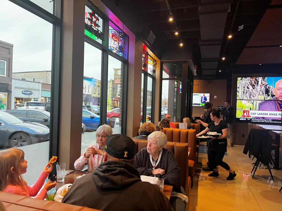 Customers sit in booths with large windows overlooking Fifth Street in Valley Junction at Bix & Co.