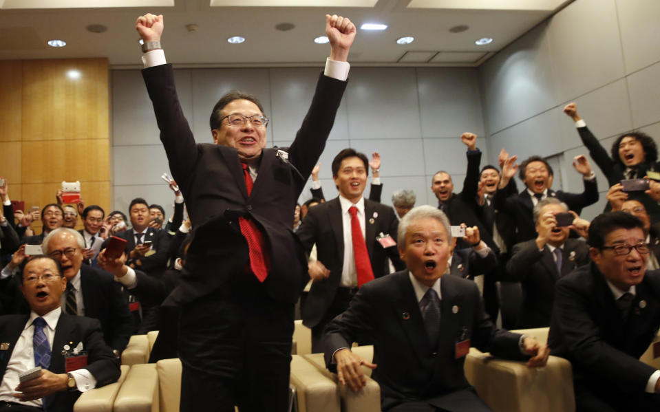 Japanese delegation with Japan's Economy, Trade and Industry Minister Hiroshige Seko, center left, Osaka Mayor Hirofumi Yoshimura, center back, and Osaka Gov. Ichiro Matsui, right, celebrate after winning the vote at the 164th General Assembly of the Bureau International des Expositions (BIE) in Paris, Friday, Nov. 23, 2018.Japan's Osaka will host the World Expo in 2025, beating out Russia, Azerbaijan for an event that attracts millions. (AP Photo/Christophe Ena)