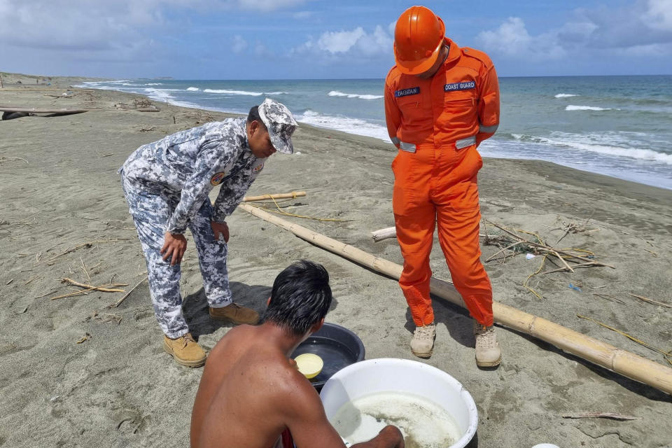 In this handout photo provided by the Philippine Coast Guard, Philippine Coast Guard personnel talk to a fisherman while conducting patrol along shore lines in Ilocos Norte province, northern Philippines, as they prepare for the possible effects of Typhoon Mawar on Monday, May 29, 2023. Philippine officials began evacuating thousands of villagers, shut down schools and offices and imposed a no-sail ban Monday as Typhoon Mawar approached the country's northern provinces a week after battering the U.S. territory of Guam. (Philippine Coast Guard via AP)