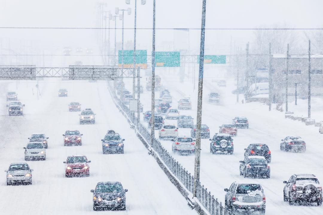 view of cars driving on freeway in both directions in blizzard conditions