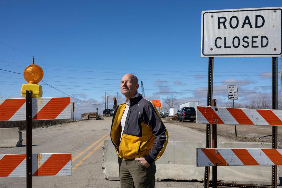 James Gardner, mayor of Luna Pier, stands next to a road-closed sign near a closed-off overpass under construction in Luna Pier on Thursday, March 7, 2024.