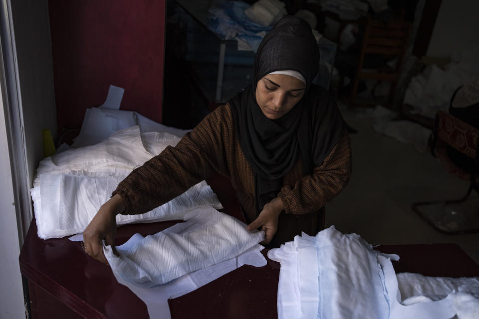 A Palestinian woman sews diapers in Rafah, southern Gaza Strip, Thursday, Feb. 15, 2024. Palestinians in Gaza have experienced severe shortages of basic necessities since the war began on Oct. 7. (AP Photo/Fatima Shbair)