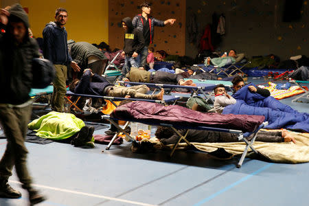 Migrants sleep in a gym after a big fire which destroyed many wood houses at a camp for migrants in Grande-Synthe near Dunkirk, France, April 11, 2017. REUTERS/Pascal Rossignol