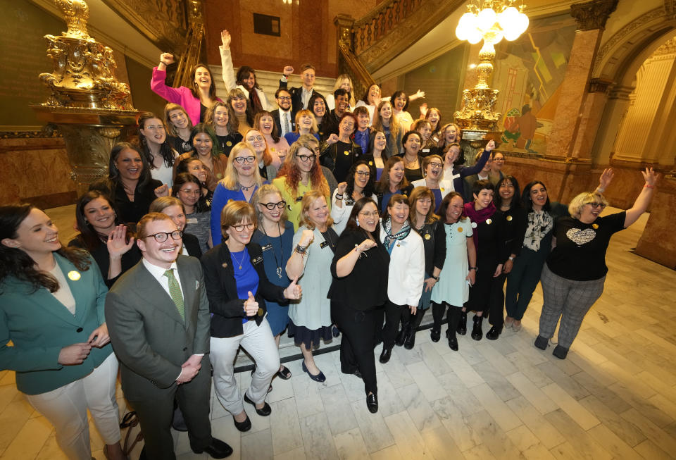 Colorado State Sen. Julie Gonzales, front center, leads fellow lawmakers and supporters in a cheer during a photograph in the rotunda after Colorado Governor Jared Polis signed three bills that enshrine protections for abortion and gender-affirming care procedures and medications during a ceremony Friday, April 14, 2023, in the State Capitol in Denver. (AP Photo/David Zalubowski)