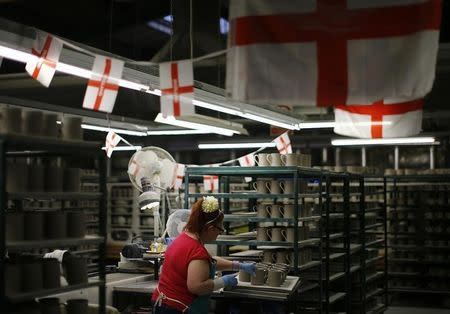 A worker puts handles on to cups at the Portmeirion Factory in Stoke-on-Trent, central England, February 16, 2015. REUTERS/Darren Staples