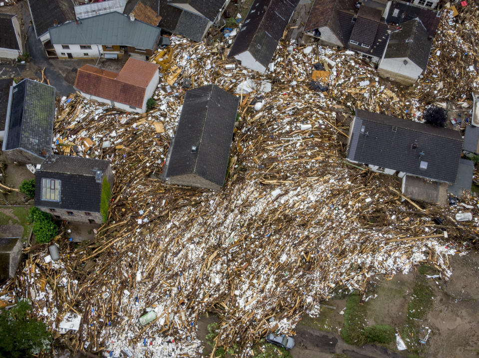 Debris of houses and trees surround houses in Schuld, Germany, Friday, July 16, 2021. Two days before the Ahr river went over the banks after strong rain falls causing severals deaths and hundreds of people missing. (AP Photo/Michael Probst)