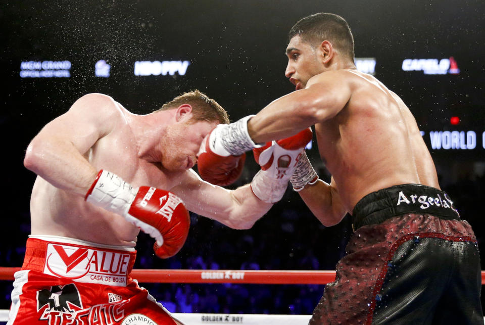 FILE - In this May 7, 2016, file photo, Canelo Alvarez, left, is hit by Amir Khan during their WBC middleweight title fight in Las Vegas. Terence Crawford (34-0, 25 KOs) defends his welterweight title at Madison Square Garden, Saturday, April 20, 2019, against veteran Khan (33-4, 20 KOs), the 2004 Olympic silver medalist from Britain who 15 years later is looking for what could be his biggest victory as a professional. (AP Photo/Isaac Brekken, File)