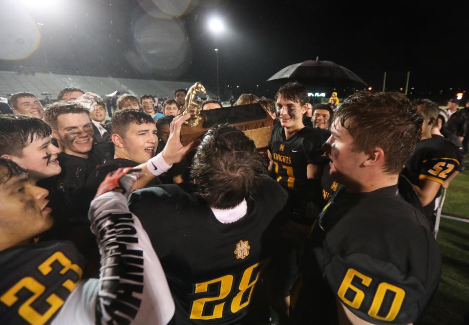 McQuaid celebrates winning the Section V Class AA championship title at SUNY Brockport on Nov. 11, 2022.  The team takes turns kissing their trophy and cheering after each kiss.  They defeated Pittsford 37-14