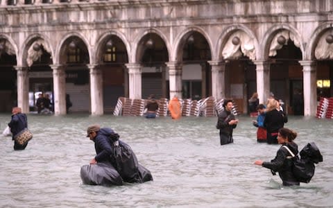 Residents and visitors were wading through waist-high water in St Mark's Square before the mayor gave orders to evacuate the area - Credit: REUTERS