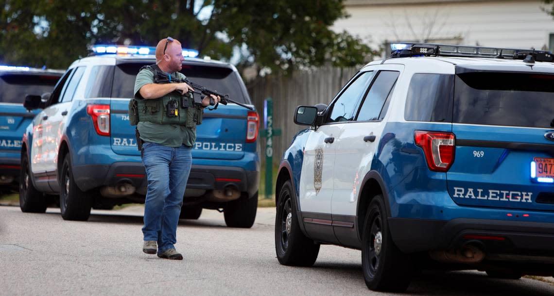 A law enforcement officer searches for the suspect in a mass shooting in the Hedingham neighborhood of Raleigh, N.C., late Thursday afternoon, Oct. 13, 2022.