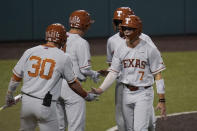 Texas' Douglas Hodo (7) celebrates with teammates after he scored against South Florida during the third inning of an NCAA Super Regional college baseball game, Sunday, June 13, 2021, in Austin, Texas. (AP Photo/Eric Gay)