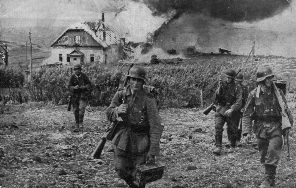 German soldiers evacuating a house in Kharkov destroyed by Russian artillery fire, circa 1943.