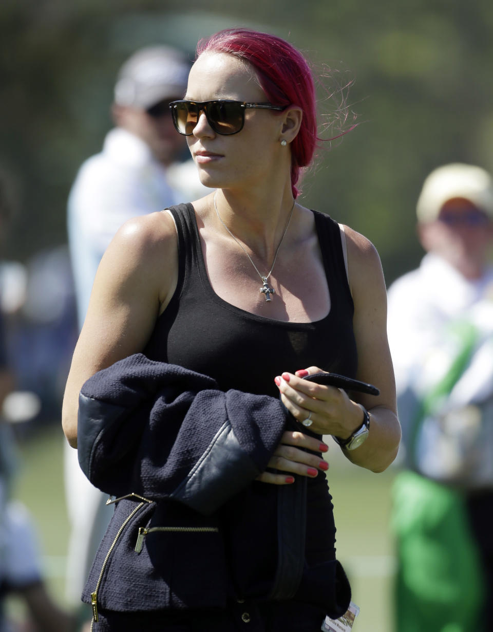 Tennis player Caroline Wozniacki watches her fiancee Rory McIlroy, of Northern Ireland, during the first round of the Masters golf tournament Thursday, April 10, 2014, in Augusta, Ga. (AP Photo/Darron Cummings)