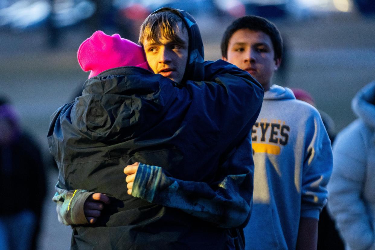 Alex Arbuckle hugs a loved one as he arrives at a candle light vigil in honor of the Perry High School shooting victims Thursday, Jan. 4, 2024, at Wiese Park in Perry.