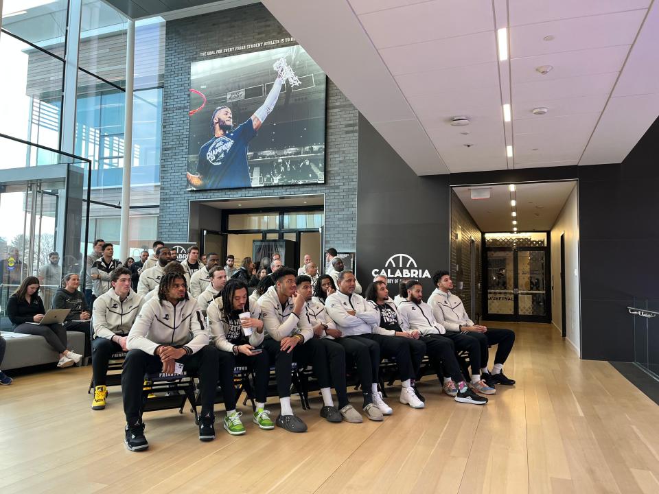 The Providence College Friars await their NCAA tournament fate Sunday on the Providence campus, with Coach Ed Cooley seated fourth from right.